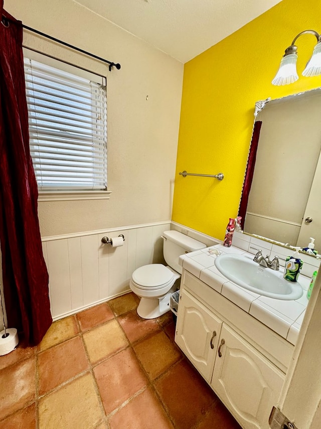 6305 Mecca St, Odessa, TX 79762 - half bathroom featuring wainscoting, toilet, and vanity
