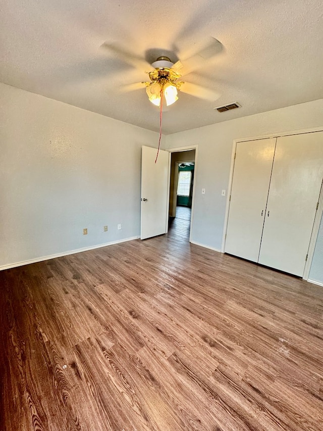 6305 Mecca St, Odessa, TX 79762 - unfurnished bedroom with wood finished floors, a textured ceiling, ceiling fan, baseboards, and a closet