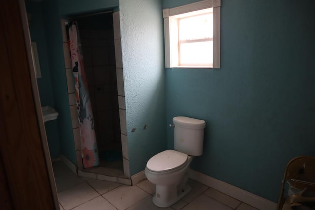 1642 S Plum Ave, Pecos, TX 79772 - bathroom featuring a shower stall, toilet, tile patterned flooring, and baseboards