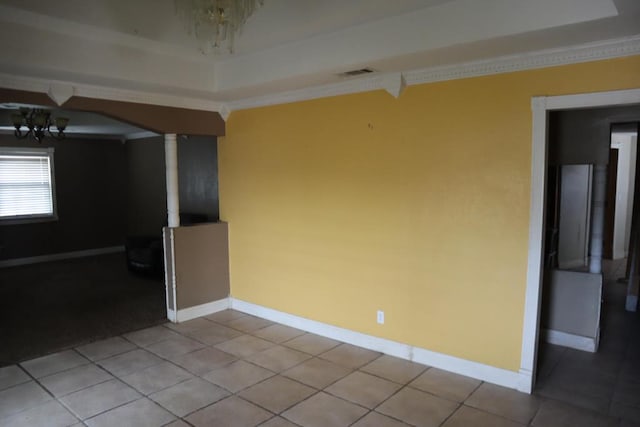 1642 S Plum Ave, Pecos, TX 79772 - tiled empty room with a chandelier, ornate columns, ornamental molding, a raised ceiling, and baseboards