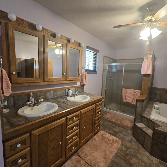 9935 W Yukon Rd, Odessa, TX 79764 - bathroom featuring a ceiling fan, a shower stall, double vanity, a garden tub, and a textured ceiling