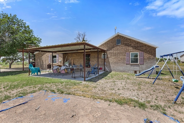 1908 W 36th St, Monahans, TX 79756 - back of house featuring a patio, a playground, and brick siding
