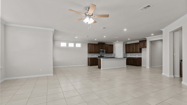 kitchen with a center island with sink, decorative backsplash, ornamental molding, dark brown cabinets, and stainless steel appliances