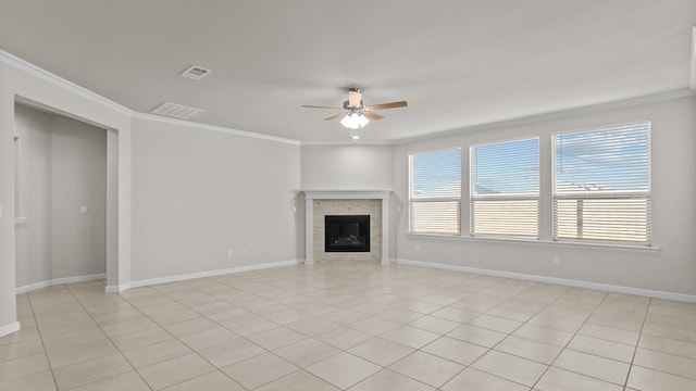 unfurnished living room with a tile fireplace, ceiling fan, light tile patterned flooring, and ornamental molding