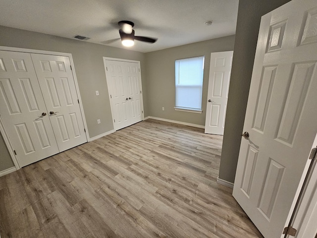 3819 Robertson Ave, Odessa, TX 79764 - unfurnished bedroom featuring two closets, light wood-type flooring, and ceiling fan