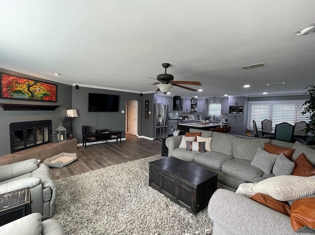 1401 S Franklin Ave, Monahans, TX 79756 - living room with dark wood finished floors, ornamental molding, ceiling fan, a textured ceiling, and recessed lighting