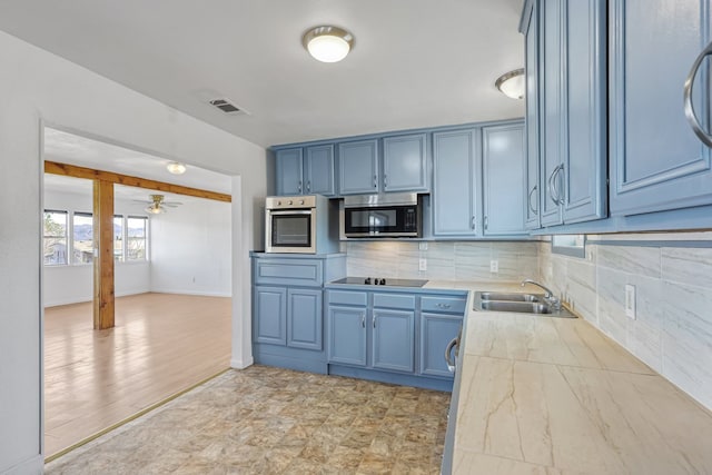 504 San Juan Dr, Fort Davis, TX 79734 - kitchen with appliances with stainless steel finishes, light countertops, blue cabinetry, and backsplash