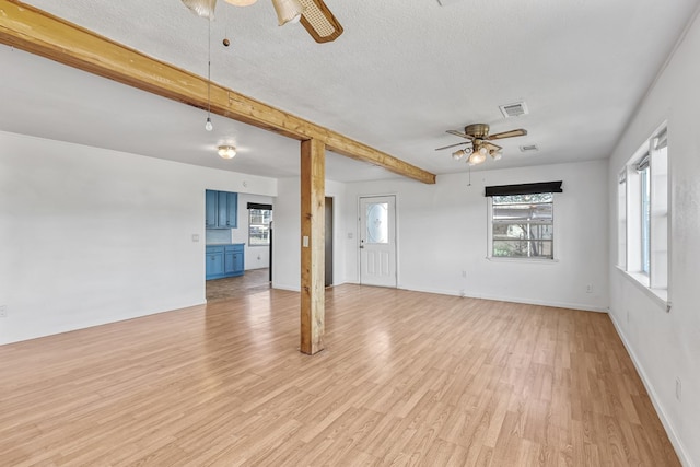 504 San Juan Dr, Fort Davis, TX 79734 - spare room with a ceiling fan, light wood-style flooring, a textured ceiling, and beam ceiling