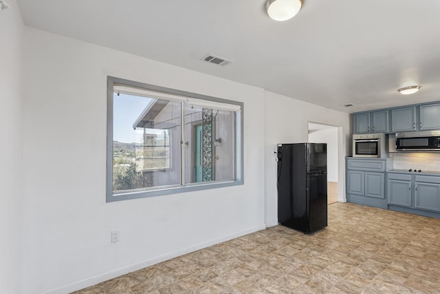 504 San Juan Dr, Fort Davis, TX 79734 - kitchen with freestanding refrigerator, stainless steel microwave, and light floors
