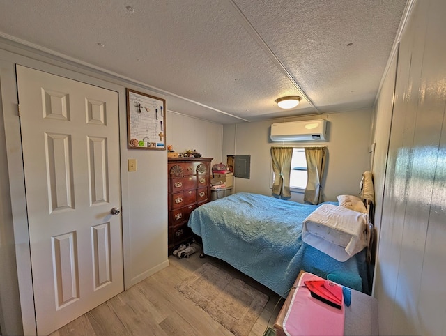 403 Commerce St, Fort Davis, TX 79734 - bedroom with electric panel, a textured ceiling, a wall unit AC, and wood finished floors