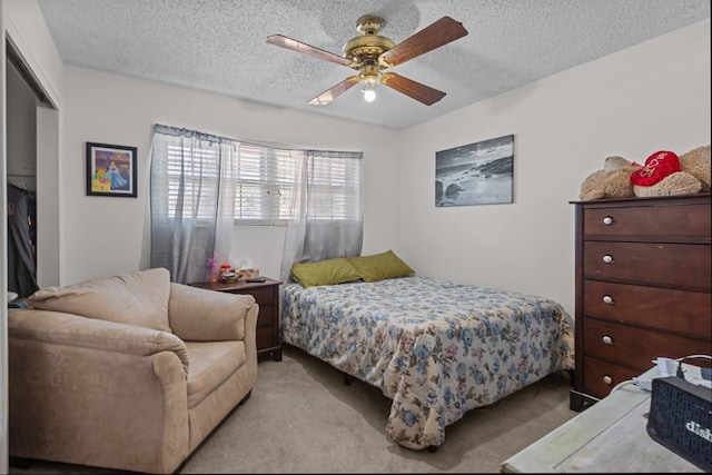 bedroom featuring light carpet, a textured ceiling, and a ceiling fan