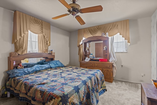 bedroom with light carpet, ceiling fan, and baseboards