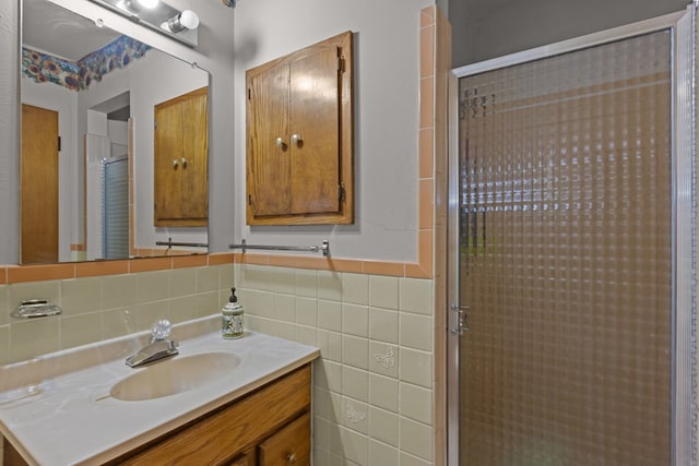 full bathroom featuring a shower stall, vanity, and tile walls