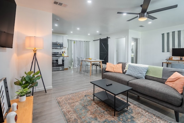 411 N San Jacinto St, Odessa, TX 79762 - living area with a barn door, a ceiling fan, light wood-style flooring, and recessed lighting