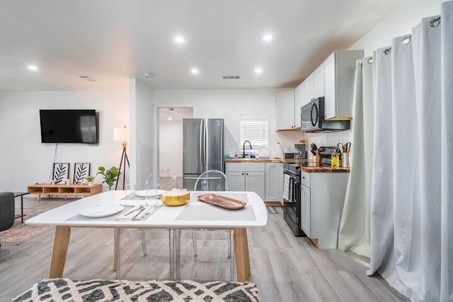411 N San Jacinto St, Odessa, TX 79762 - kitchen with freestanding refrigerator, electric range oven, wood counters, light wood-style flooring, and recessed lighting