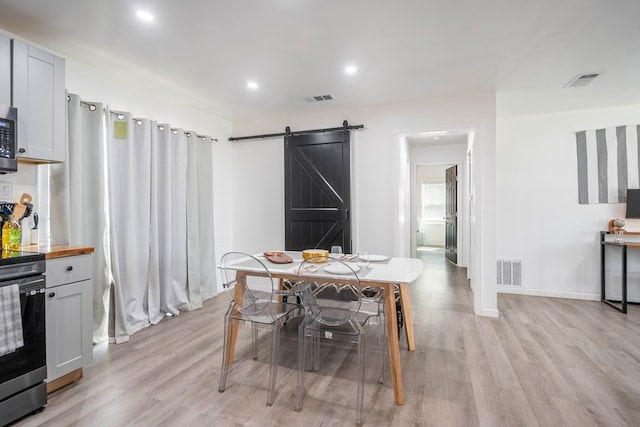 411 N San Jacinto St, Odessa, TX 79762 - dining room with a barn door, light wood-style floors, and recessed lighting