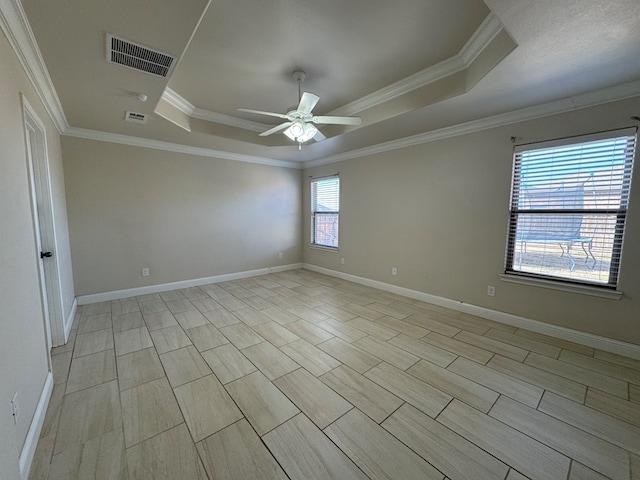 empty room featuring a raised ceiling, ceiling fan, and crown molding