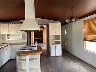 7720 W 26th St, Odessa, TX 79764 - kitchen with island range hood, a chandelier, dark wood finished floors, white cooktop, and hanging light fixtures
