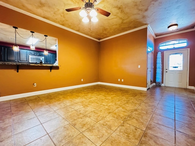 unfurnished room with light tile patterned floors, baseboards, ornamental molding, and a ceiling fan