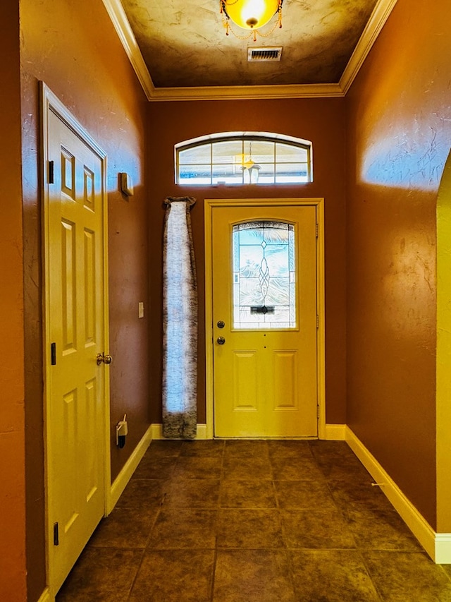 tiled entrance foyer with visible vents, crown molding, and baseboards