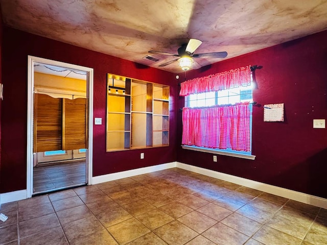 spare room with visible vents, baseboards, and ceiling fan