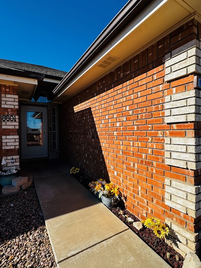 view of exterior entry with brick siding