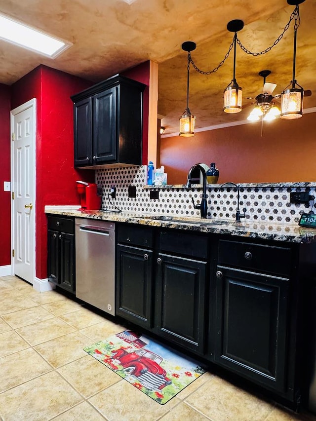 kitchen with light tile patterned floors, dark cabinetry, and stainless steel dishwasher