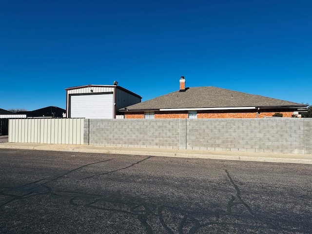 view of home's exterior with an outdoor structure and fence