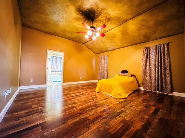 unfurnished bedroom featuring lofted ceiling, baseboards, and wood finished floors