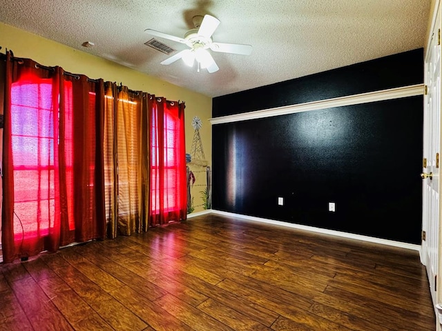 unfurnished room featuring visible vents, a textured ceiling, a ceiling fan, and hardwood / wood-style flooring