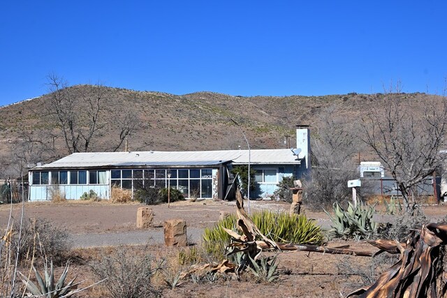 back of property featuring a sunroom and a mountain view