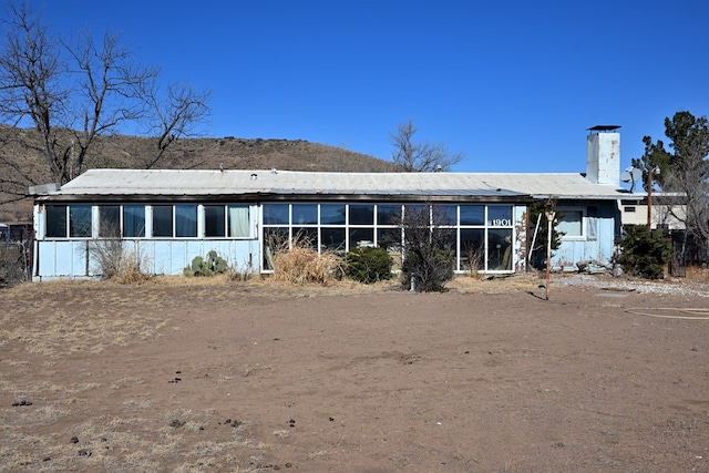 back of house with a sunroom and metal roof