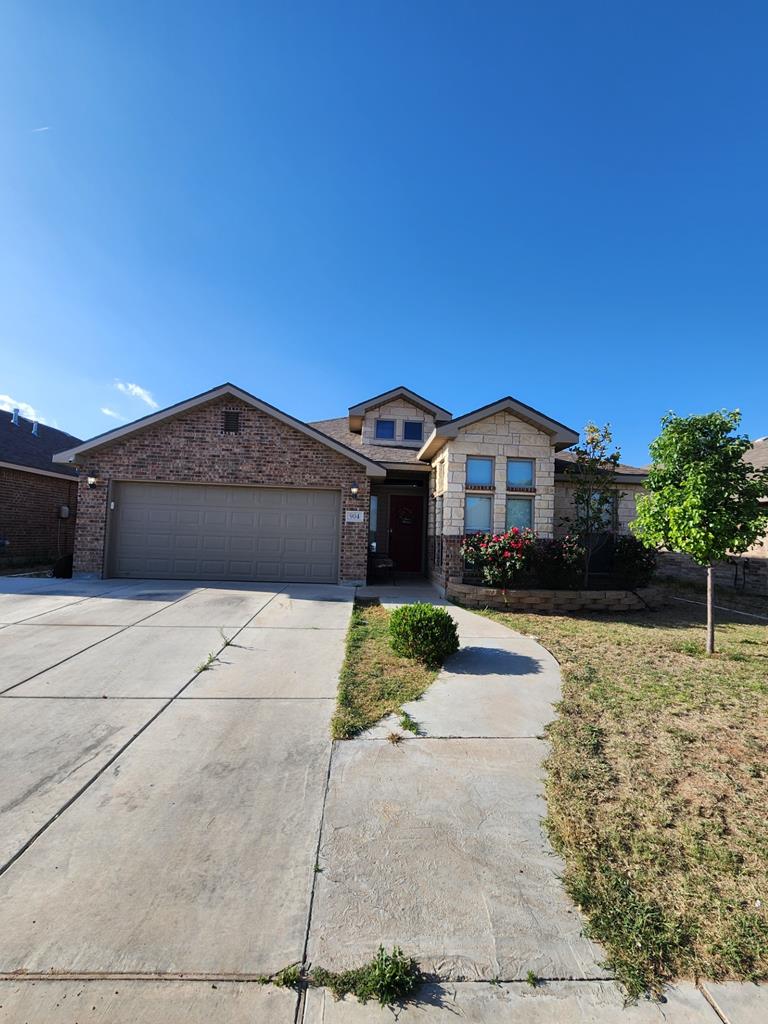 ranch-style home featuring a garage, stone siding, driveway, and brick siding