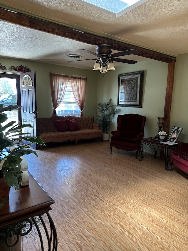 1001 Dorothea St, Crane, TX 79731 - living area with light wood-style flooring, a ceiling fan, a skylight, a textured ceiling, and visible vents