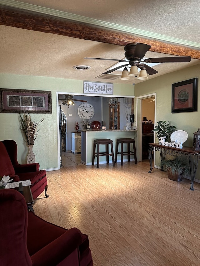 1001 Dorothea St, Crane, TX 79731 - living area featuring ceiling fan, a textured ceiling, visible vents, and wood finished floors