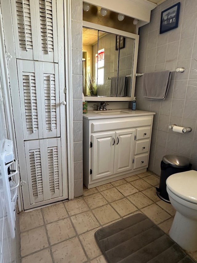 1001 Dorothea St, Crane, TX 79731 - bathroom with toilet, tile walls, and vanity