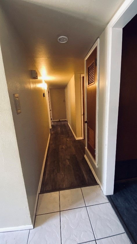 hallway featuring baseboards and tile patterned floors