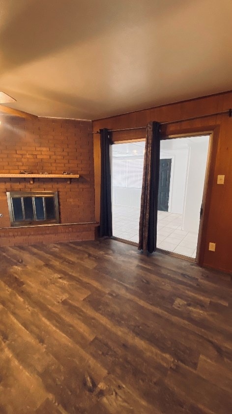 unfurnished living room with a fireplace, wood finished floors, and a ceiling fan