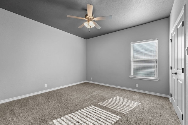unfurnished room with a ceiling fan, baseboards, and carpet floors
