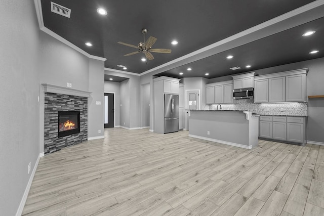 kitchen featuring a ceiling fan, visible vents, open floor plan, stainless steel appliances, and light wood-type flooring