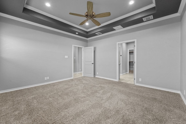 unfurnished bedroom featuring carpet flooring, a tray ceiling, visible vents, ornamental molding, and recessed lighting