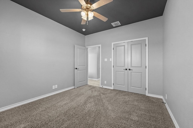 unfurnished bedroom with a closet, visible vents, carpet floors, a ceiling fan, and baseboards