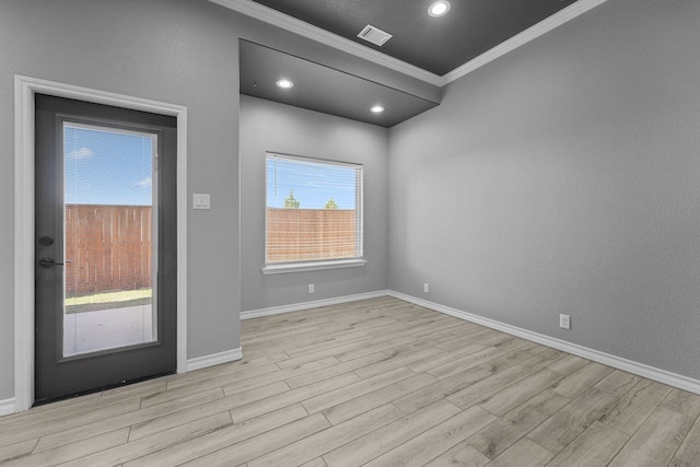 unfurnished room with baseboards, ornamental molding, visible vents, and wood finished floors