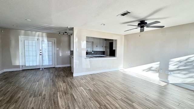 entrance foyer with hardwood / wood-style flooring, ceiling fan, a textured ceiling, and french doors