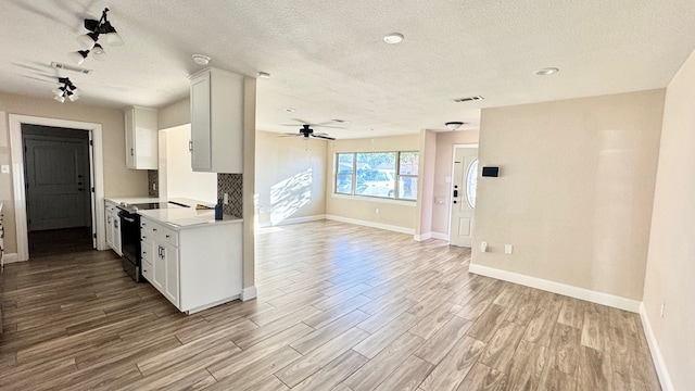 kitchen featuring range with electric stovetop, white cabinetry, a textured ceiling, and light hardwood / wood-style floors