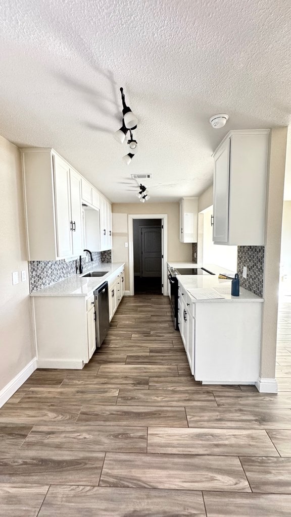 kitchen with tasteful backsplash, appliances with stainless steel finishes, sink, and white cabinets