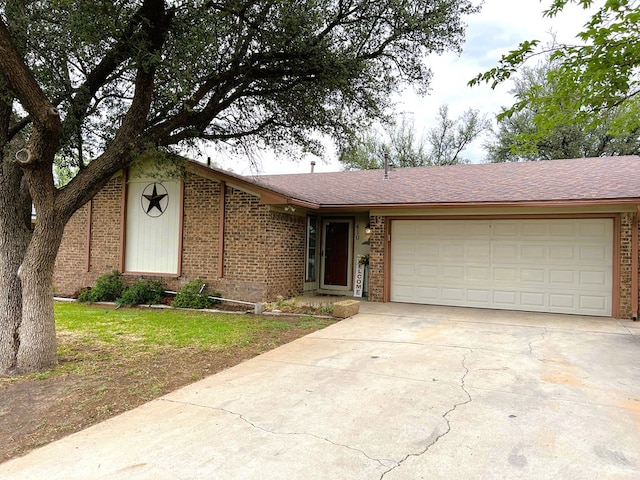 single story home with brick siding, concrete driveway, an attached garage, and a shingled roof
