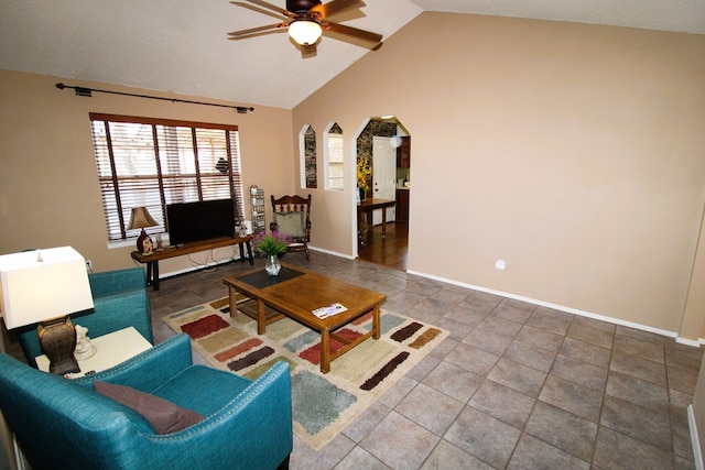 living area featuring a ceiling fan, arched walkways, lofted ceiling, and baseboards