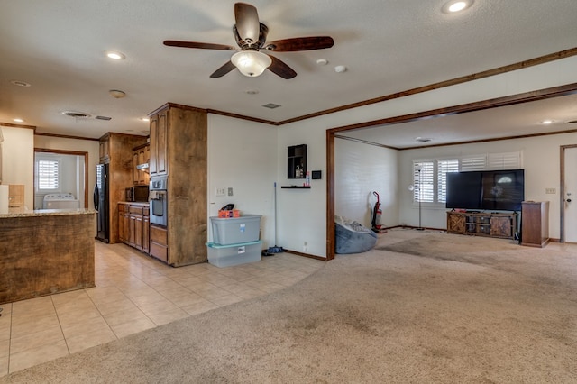 unfurnished living room featuring washer / dryer, light colored carpet, ceiling fan, and a healthy amount of sunlight