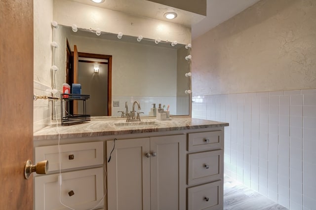 bathroom featuring tile walls, hardwood / wood-style floors, and vanity